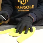Handsole craftsman cutting a leather shoe upper pattern by hand in the workshop