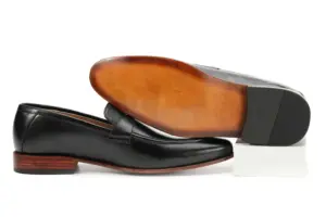 Black leather swirl-strap loafer with its warm brown finished outsole