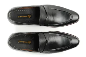 Overhead view of black leather swirl-strap loafers with Handsole insoles