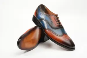 Angled view of cognac-blue wingtip Oxford shoes and finished outsole