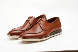 Pair of cognac brown apron-toe casual Derby shoes with cream ridged soles