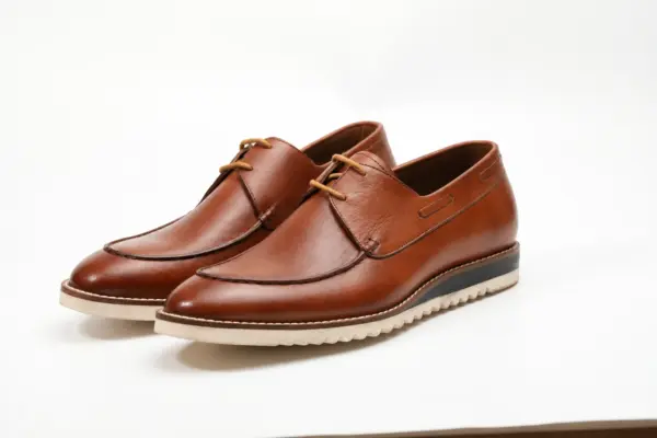 Pair of cognac brown apron-toe casual Derby shoes with cream ridged soles