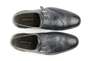 Top view of grey-black patina single monk shoes with wingtip perforations and Handsole insoles