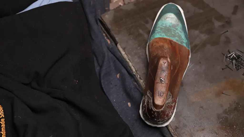Artisan hand-stitching leather upper with reinforced stress point stitching