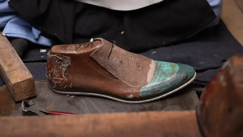 Artisan hand-stitching leather upper with reinforced stress point stitching