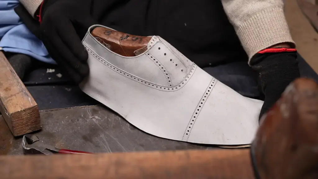 Artisan hand-stitching leather upper with reinforced stress point stitching