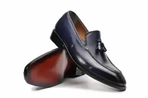Angled view of purple-black tassel loafers showing the finished red-brown sole