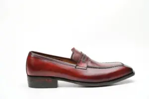 Side profile of red-burgundy patina penny loafer