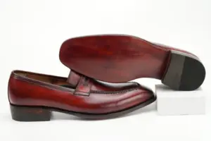 Red-burgundy penny loafer with its finished red-brown outsole