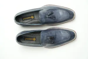 Top view of the pair of grey leather tassel loafers showing both aprons, tassels and black branded insoles