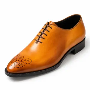Angled view of one tan Oxford shoe with decorative perforations on the almond-shaped toe