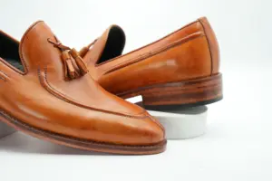 Close-up of tan apron toe tassel loafer and leather tassels