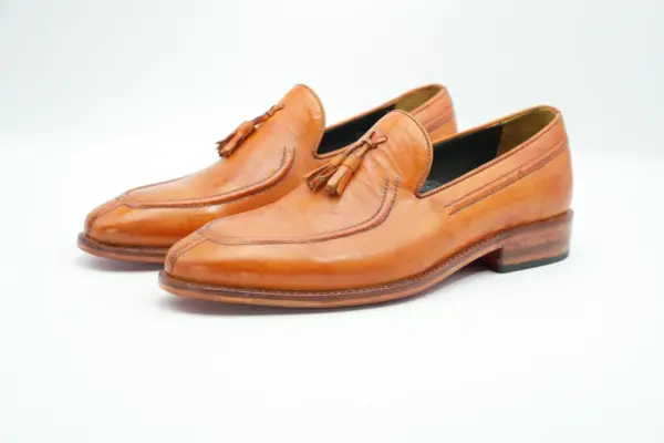 Tan apron toe tassel loafers, three-quarter pair view