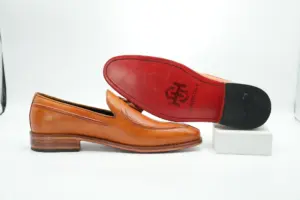 Red-finished leather sole on tan tassel loafer