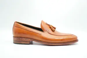 Tan tassel loafer side profile with tonal hand finishing