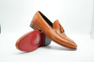 Angled sole view of tan tassel loafers