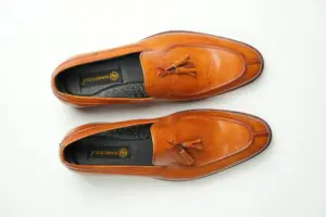 Top view of tan tassel loafers with stitched apron