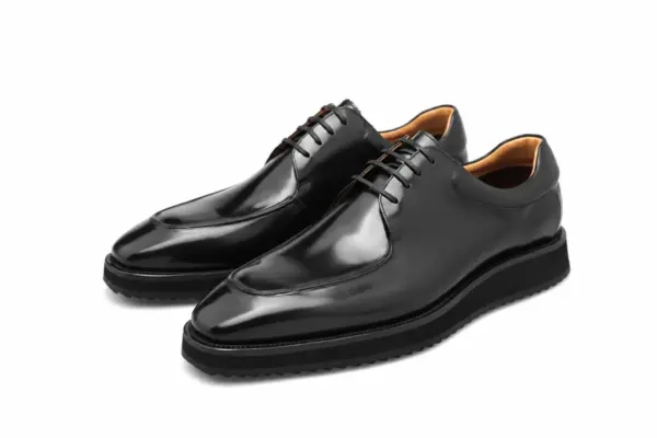 Black hand-painted apron-toe Derby shoes with padded collars and ridged rubber soles, pair