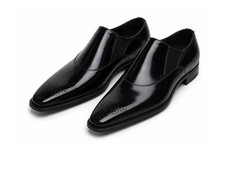 Pair of black polished leather elastic-gore slip-on dress shoes with toe medallion