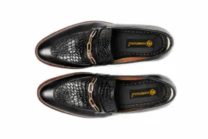 Overhead view of black chain loafers showing croc-pattern aprons and branded insoles