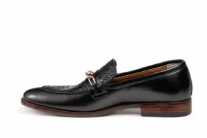 Side profile of black croc-pattern chain loafer with brown heel