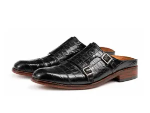 Front three-quarter view of black croc-pattern double buckle mules