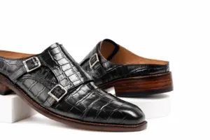 Close-up of black croc-pattern texture, square toe and two silver-tone buckles