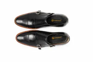 Overhead pair of black leather cap-toe double monk strap shoes