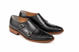 Three-quarter pair of black double monk straps with warm brown heels