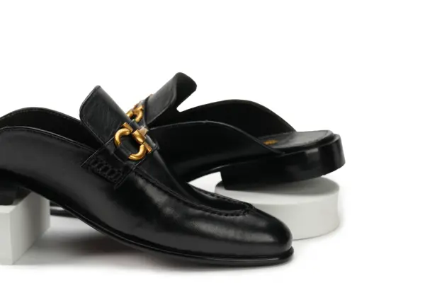 Black leather open-back mule with decorative buckle, pair view