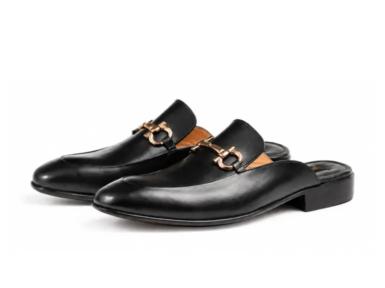 Three-quarter view of black horsebit mules with smooth uppers and low dark heels