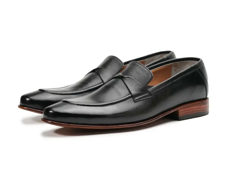 Pair of black leather swirl-strap loafers with stitched apron toes