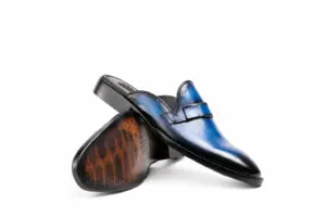 Blue-Black Striped Patina Penny Mule: angled sole showing the brown outsole and dark heel.