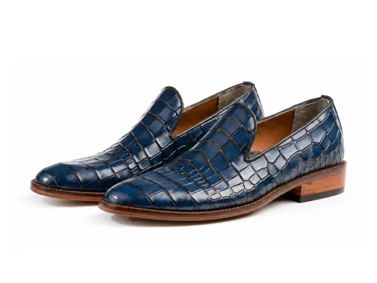 Pair of blue croc-pattern plain leather loafers on white background