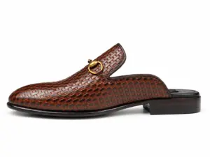 Side view of a brown-black basket-pattern mule with a gold-tone horsebit