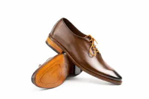 Angled brown burnished wholecut Oxford above leather sole