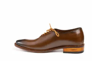 Side profile of brown wholecut Oxford with layered heel