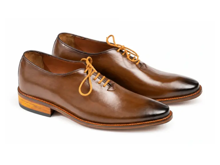 Three-quarter pair view of brown wholecut Oxfords with darkened toes