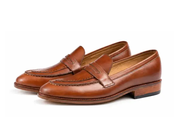 Pair of brown pull-up leather penny loafers showing the forepart and sole profile