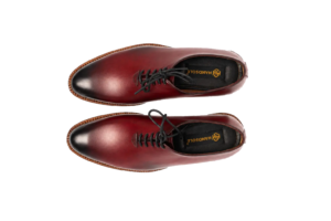 Overhead pair of oxblood wholecut Oxford shoes showing elongated almond toes, black laces and Handsole footbeds