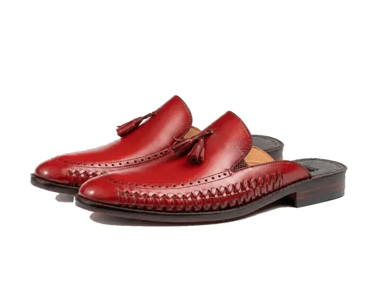 Opposite three-quarter pair of burgundy woven tassel mules showing apron toes and open backs