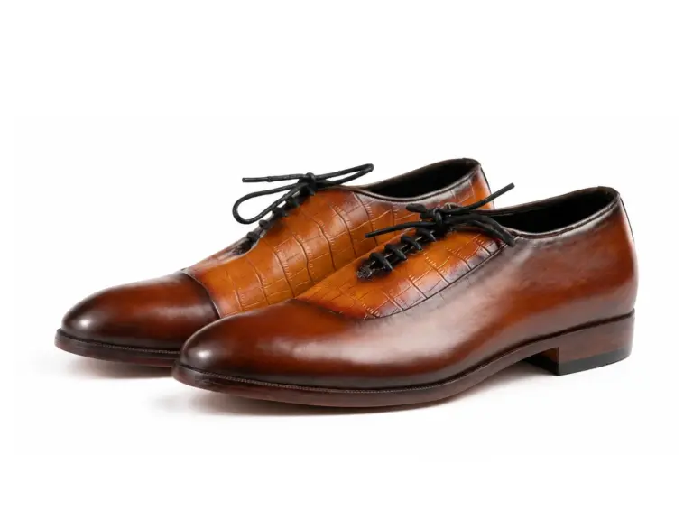 Pair of cognac and brown croc-pattern panel cap-toe Oxford shoes showing the forepart and sole profile