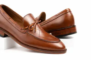 Close view of cognac loafer criss-cross apron and leather bow tie