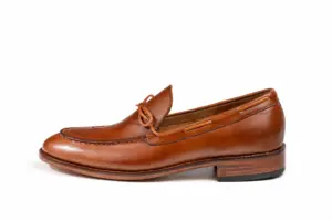 Side profile of cognac tie loafer showing side lacing and layered heel