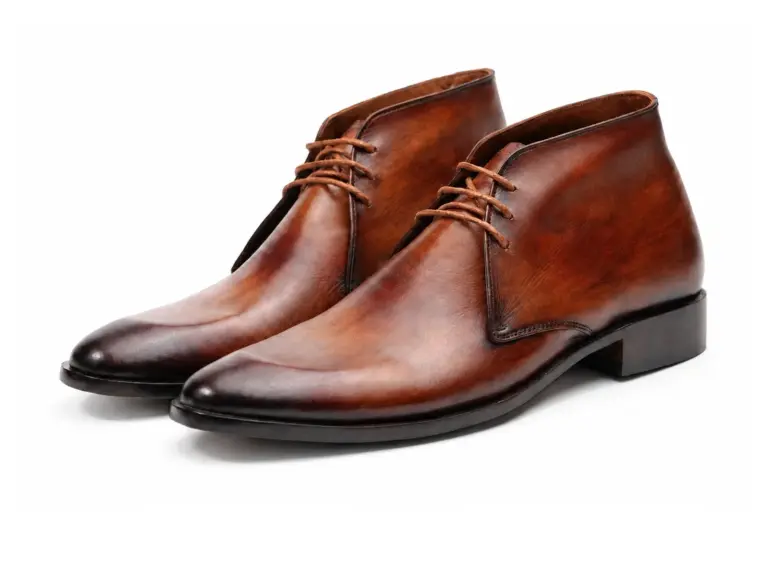 Pair of cognac burnished three-eyelet chukka boots in three-quarter view