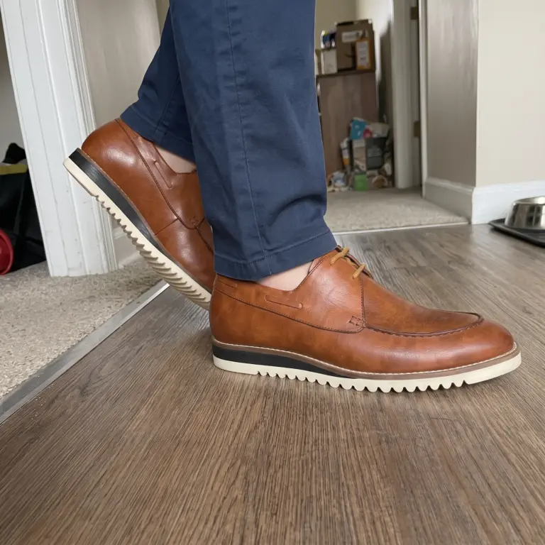 Customer wearing cognac apron toe Derby shoes with white Vibram soles and navy chinos
