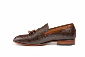 Opposite side profile of brown lizard-pattern tassel loafer showing textured quarters and almond toe