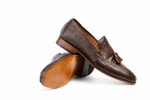 Angled pair of dark brown tassel loafers showing the finished outsole and heel