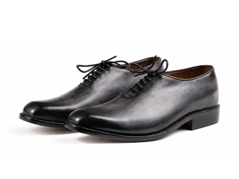 Pair of grey-black patina square-toe wholecut Oxfords on white background