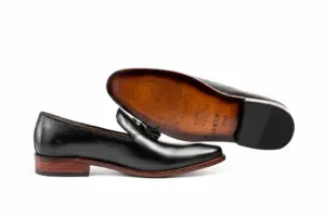 Brown HANDSOLE-branded leather outsole and dark heel top lift of the black tassel loafer